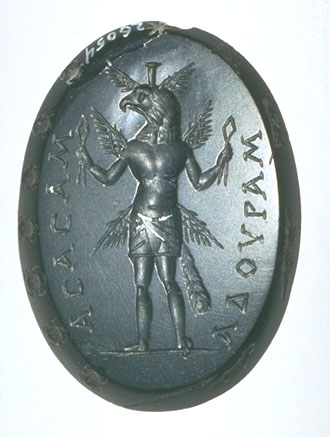 Eagle-headed
 god wearing only an apron,
 calathus on head, six wings, bird tail. In its hands, Egyptian sa amulets.
Inscrip.: asasam adouram.Bevel: Seven scarab beetles, a star, a cynocephalus, a crocodile,
 and several obscure figures.
